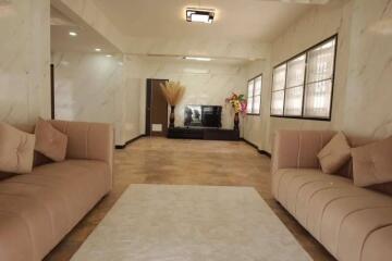 Spacious modern living room with two beige sofas, a white coffee table, and a TV on a stand