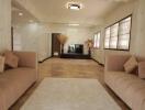 Spacious modern living room with two beige sofas, a white coffee table, and a TV on a stand