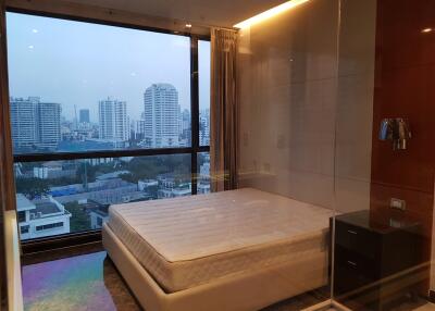 Bedroom with a large window and city view