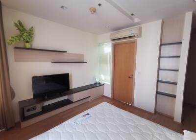 Bedroom with TV, shelves, and air conditioner