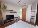 Bedroom with TV, shelves, and air conditioner