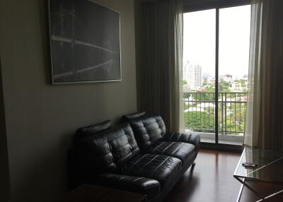 Living room with black leather sofa and large window