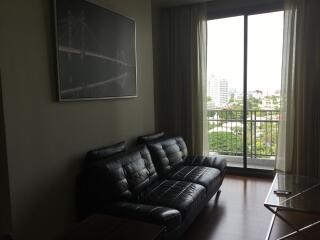 Living room with black leather sofa and large window