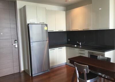 Modern kitchen with white cabinets, dark countertops, and stainless steel appliances