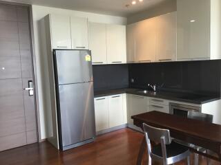 Modern kitchen with white cabinets, dark countertops, and stainless steel appliances