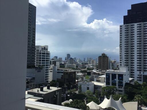 Cityscape view from a high vantage point, featuring skyscrapers and cloudy sky