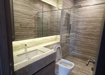 Modern bathroom with glass-enclosed shower, toilet, and sink