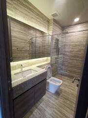 Modern bathroom with glass-enclosed shower, toilet, and sink