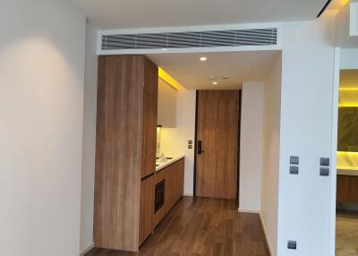 Modern kitchen entrance with wooden flooring and built-in appliances