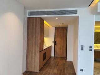 Modern kitchen entrance with wooden flooring and built-in appliances