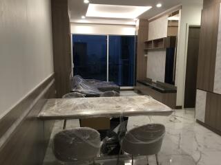 Modern living area with dining table and chairs covered in protective plastic