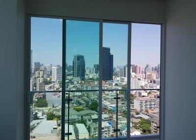 Bedroom with a large window providing a cityscape view