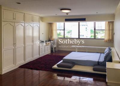 Spacious bedroom with wooden floor and large windows