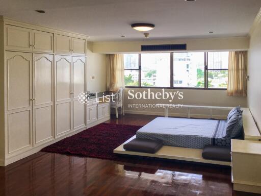 Spacious bedroom with wooden floor and large windows