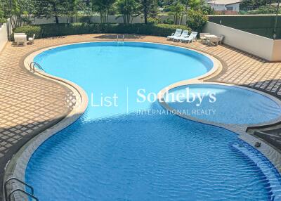 View of outdoor swimming pool with surrounding cityscape