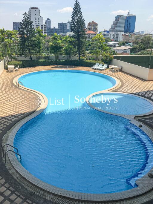 View of outdoor swimming pool with surrounding cityscape