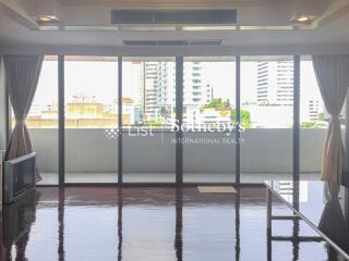 Bright living room with large windows offering city view.