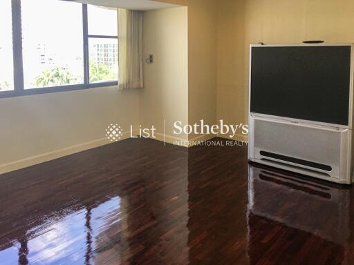 Spacious living room with a large window and a TV stand