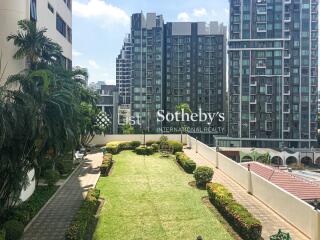 A well-maintained communal garden with modern high-rise buildings in the background