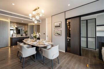 Modern dining room with elegant table setup and contemporary lighting.