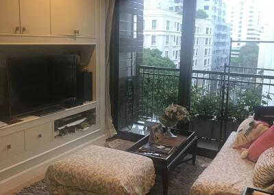 Cozy living room with a TV, ottoman, sofa, and a view of the city.