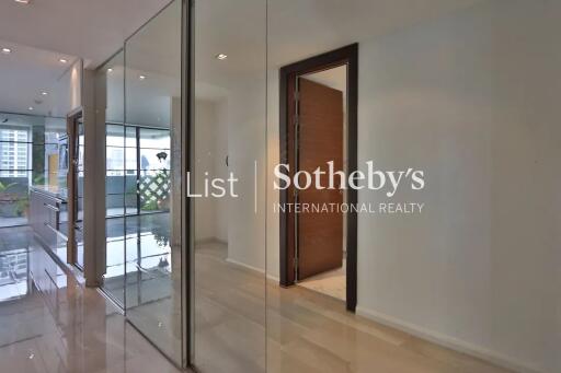 Modern hallway with glass walls and wooden door