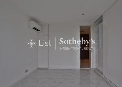 Empty room with white walls and tiled floor, featuring an air conditioning unit and a sliding door