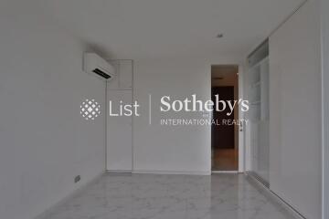 Empty room with white walls and tiled floor, featuring an air conditioning unit and a sliding door