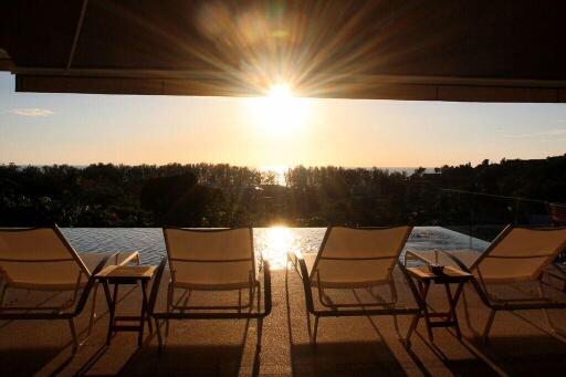 Outdoor pool area at sunset with lounge chairs