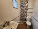 Bathroom with sink, mirror, toilet, and shower with tiled wall