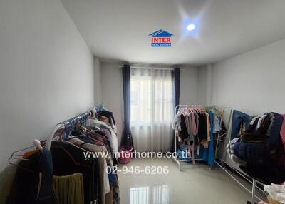 Bedroom with clothes racks and window