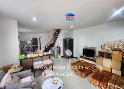 Cozy living area with staircase and various storage boxes and chairs