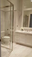 Modern bathroom with glass shower and white cabinetry