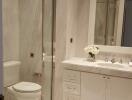 Modern bathroom with glass shower and white cabinetry