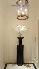 Elegant hallway with modern chandelier and floral decoration