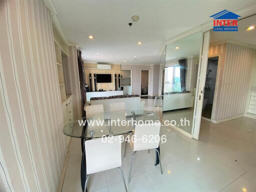 Modern dining area with glass table and white chairs