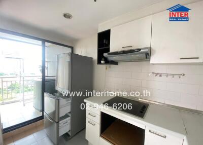 Modern kitchen with white cabinets, stainless steel appliances, and a balcony view.