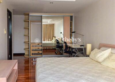 Spacious bedroom with large mirror wardrobe and desk