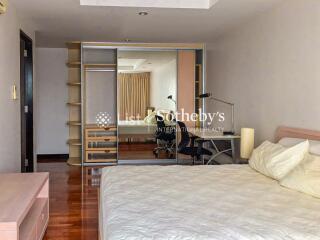 Spacious bedroom with large mirror wardrobe and desk