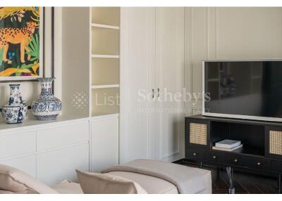 Modern living room with a TV, shelves, decorative vases, and a painting.