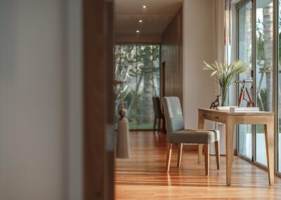 Spacious hallway with wooden flooring, large window, and a desk