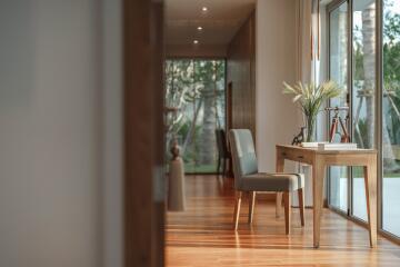 Spacious hallway with wooden flooring, large window, and a desk