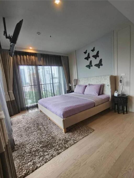 Modern bedroom with large windows and wall-mounted TV