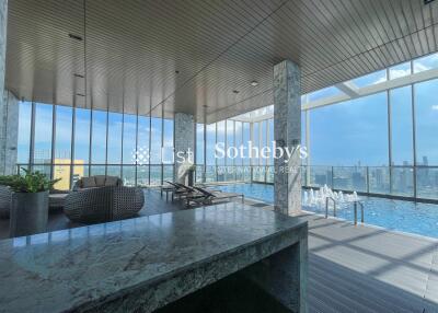 Indoor pool area with lounge chairs and city view