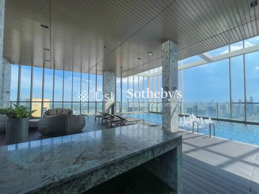 Indoor pool area with lounge chairs and city view