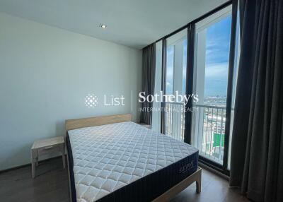 Bedroom with bed, side table, large windows and a view