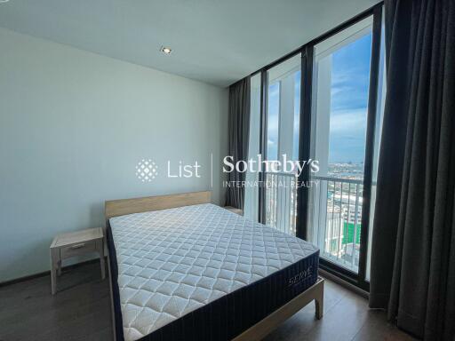 Bedroom with bed, side table, large windows and a view