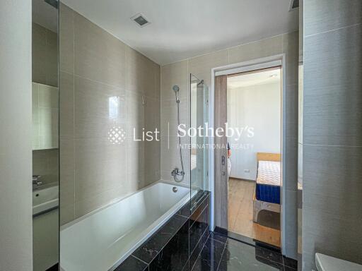 Modern bathroom with bathtub and view into bedroom