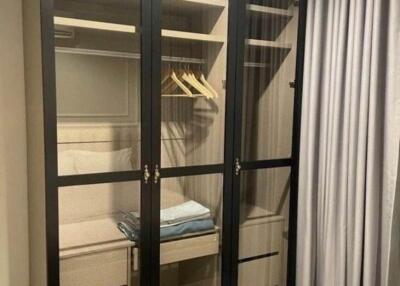 Bedroom closet with glass-paneled doors and storage drawers