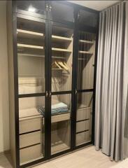 Bedroom closet with glass-paneled doors and storage drawers